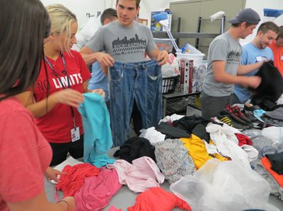 People folding clothes around a table